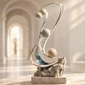 Foldback Trajectory sculpture – three stone spheres on sweeping silver arc above blue crystal base and raw travertine rock, displayed in bright arched gallery, full product view